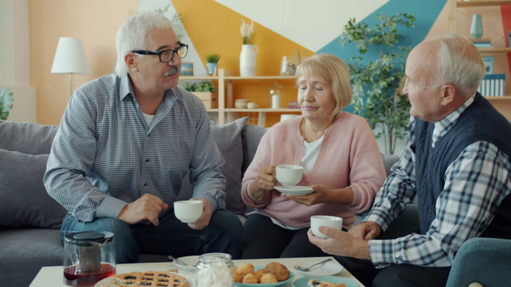 Three older adults enjoying coffee and conversation at home