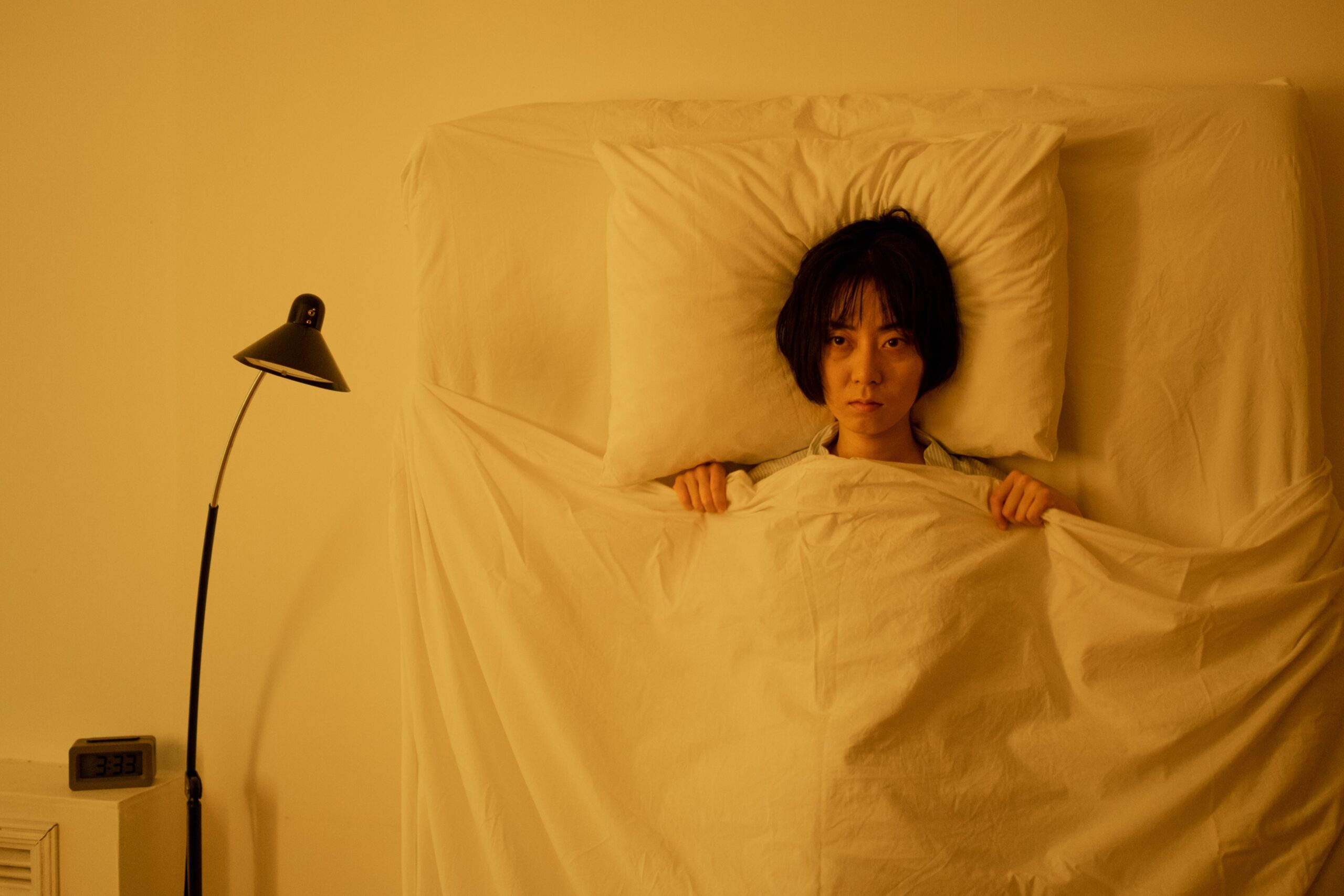 Woman awake in bed at night having trouble staying asleep