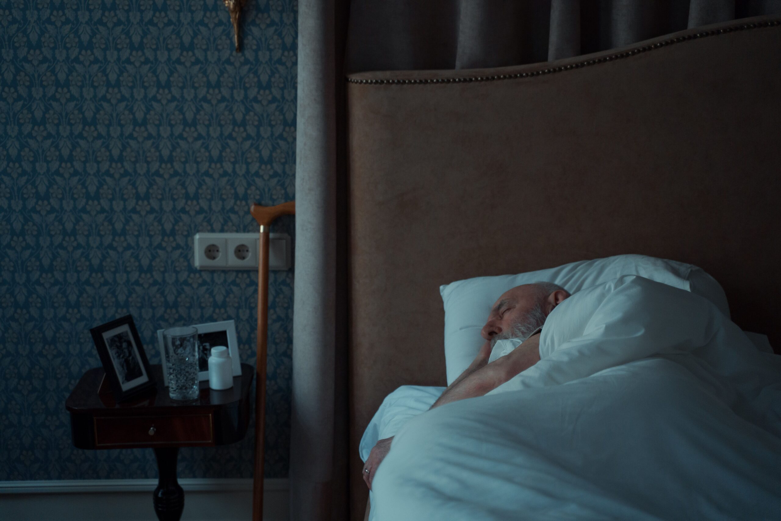 Older man sleeping in bed